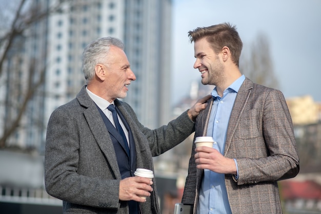 Jovem empresário e seu mentor maduro sorrindo enquanto conversam