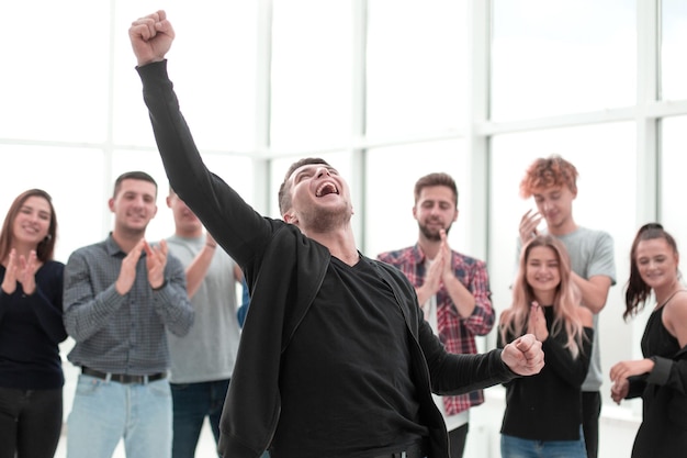 Jovem empresário em frente à equipe de negócios aplaudindo