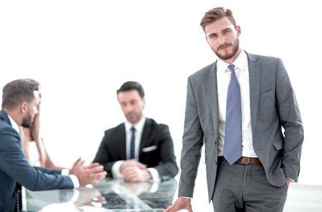 Foto jovem empresário em pé perto da mesa do escritório