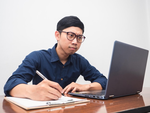 Jovem empresário escrevendo caneta séria trabalhando no espaço de trabalho da mesa