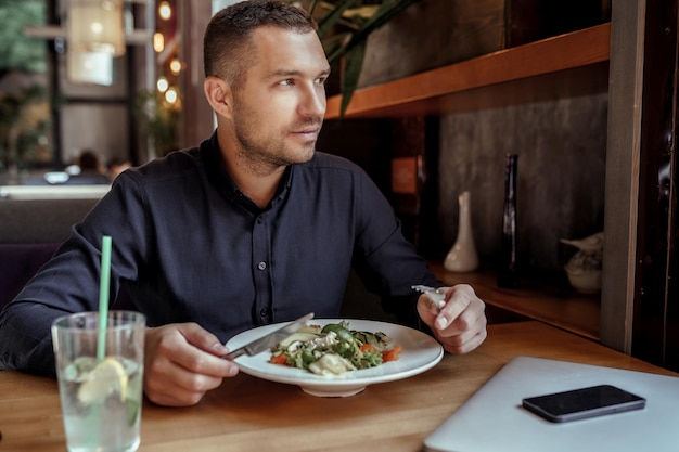 Jovem empresário está almoçando em restaurante