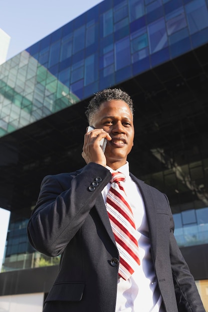 Jovem empresário falando ao telefone olhando para a câmera