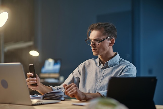 Jovem empresário fazendo anotações no trabalho à noite