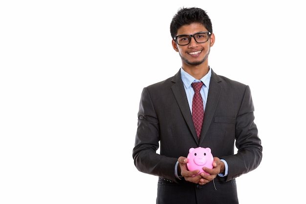 jovem empresário indiano feliz sorrindo enquanto segura o cofrinho