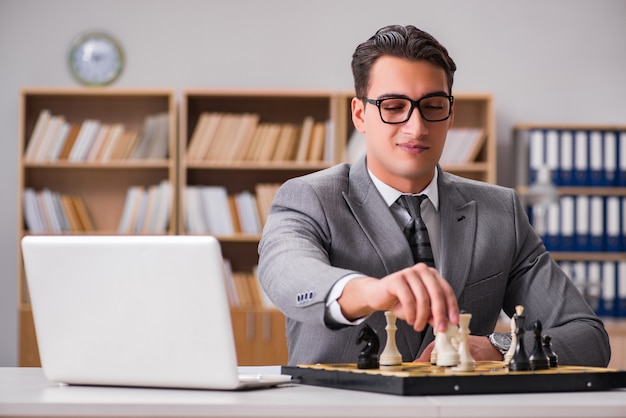 Jovem empresário jogando xadrez no escritório