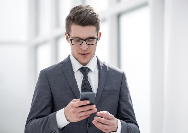 Jovem empresário lendo SMS em sua foto de smartphone com espaço de cópia