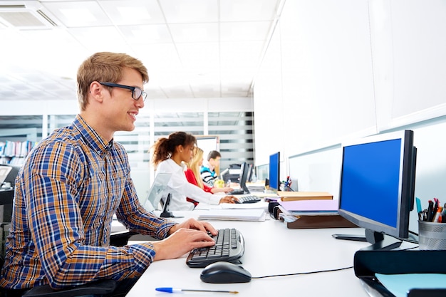 Jovem empresário loiro no escritório com computador