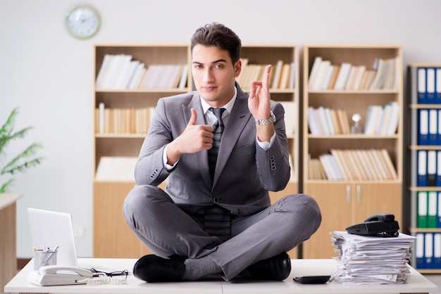 Jovem empresário meditando no escritório