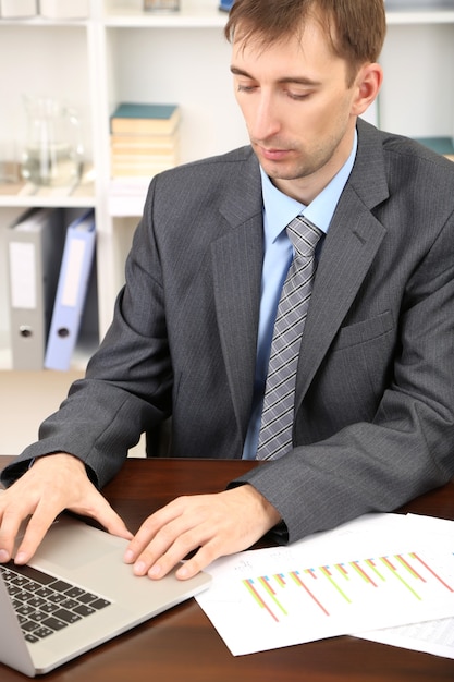 Foto jovem empresário no escritório em seu local de trabalho