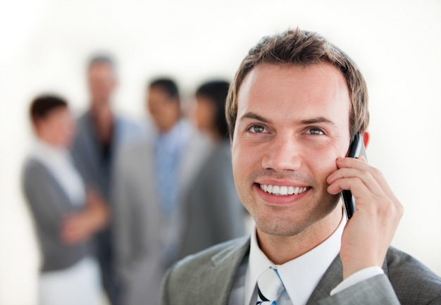 Jovem empresário no telefone na frente de seu time