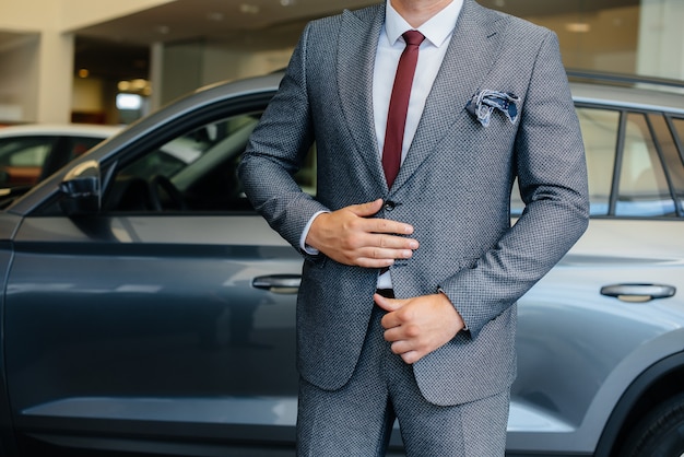 Jovem empresário olha um carro novo em uma concessionária