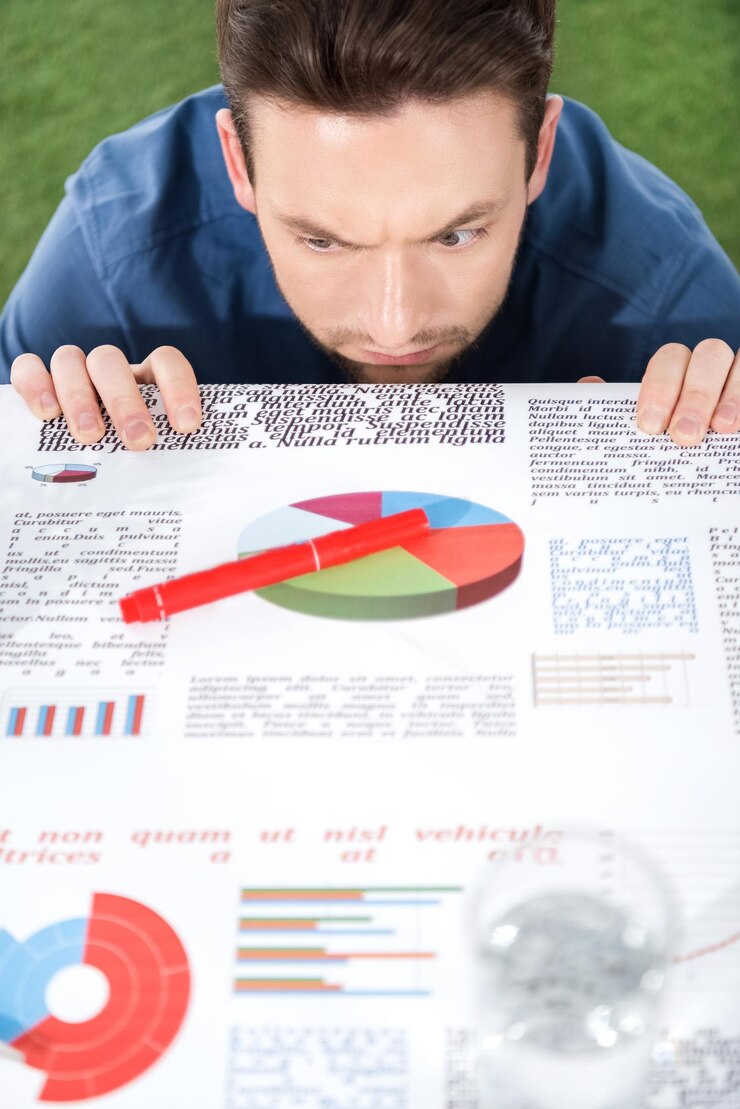 Foto jovem empresário olhando documentos com gráficos de negócios e estabelecimento de negócios de diagramas
