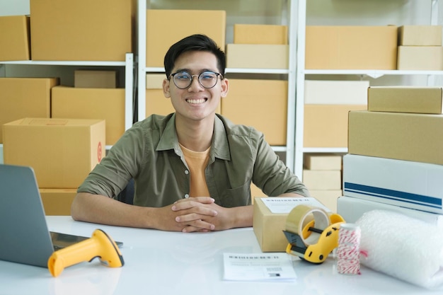 Jovem empresário on-line masculino trabalhando e olhando para a câmera