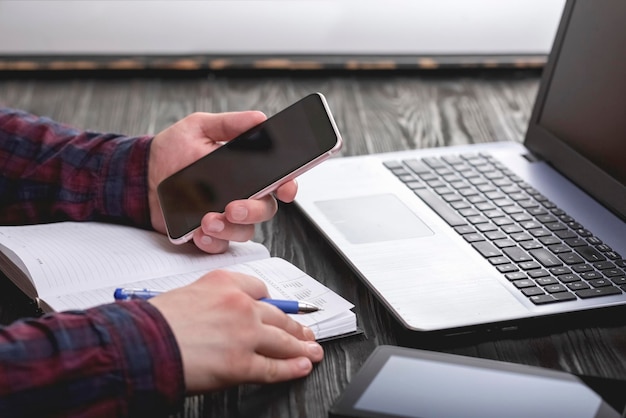 Foto jovem empresário ou freelancer trabalhando com documentos e com escritório remoto de laptop e smartphone