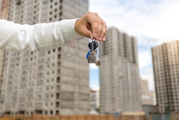 Jovem empresário segurando as chaves de uma nova imobiliária