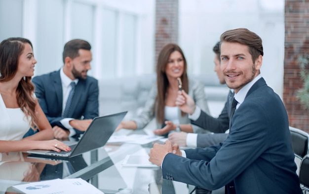 Jovem empresário sentado à mesa do escritório