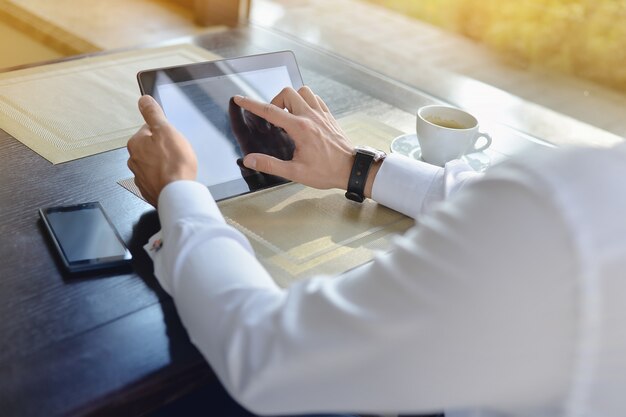 Jovem empresário sentado no café com laptop