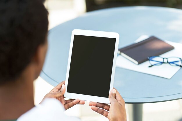 Jovem empresário sentado no local de trabalho segurando um tablet digital com tela em branco verificando maquete de correio trabalho remoto Anúncio de conceito de negócio