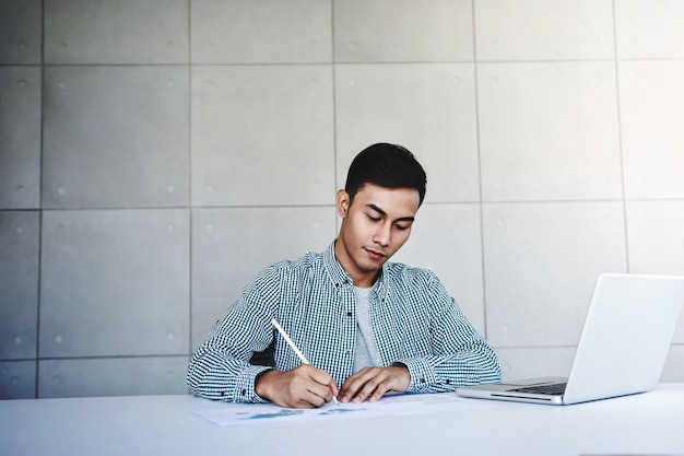 Jovem empresário trabalhando no computador portátil no escritório