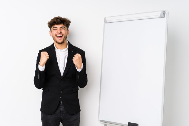 Jovem empresário, treinador árabe, torcendo despreocupado e animado. Conceito de vitória.