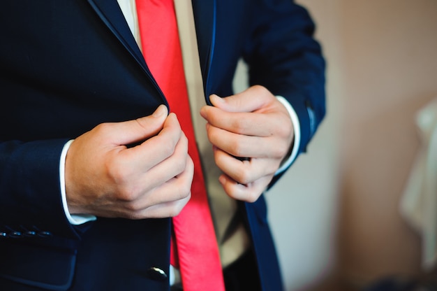 Jovem empresário veste um terno antes de encontrar os parceiros.