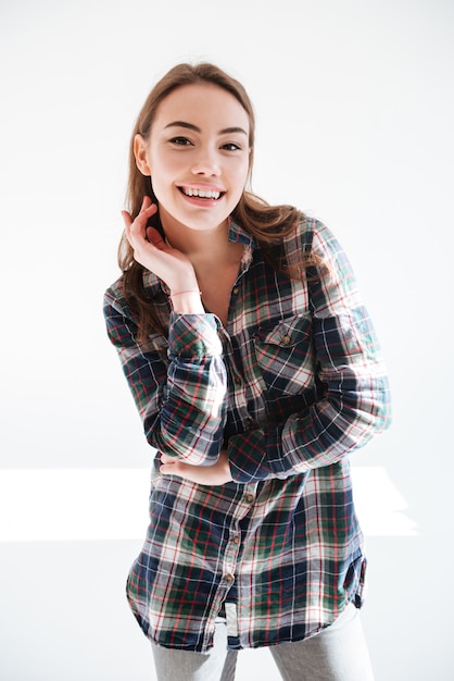 Foto jovem encantadora alegre em camisa quadriculada posando e sorrindo