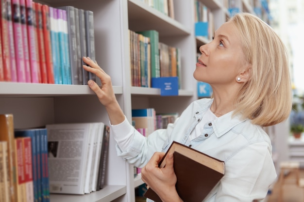 Jovem encantadora na biblioteca ou livraria