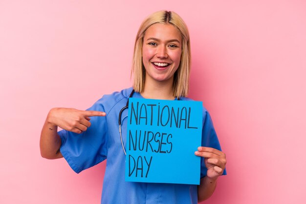 Jovem enfermeira segurando uma bandeira internacional de enfermeiras isolada em fundo rosa