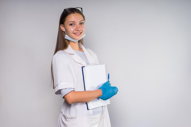 Foto jovem enfermeira sorrindo segurando um caderno nas mãos