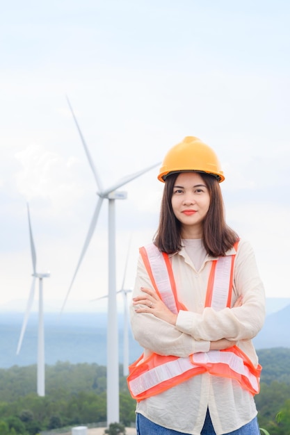 Jovem engenheira com moinho de vento em uma estação de geração de energia renovável em um campo de moinho de vento