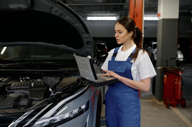 Jovem engenheira de automóveis fornecendo diagnósticos de computador