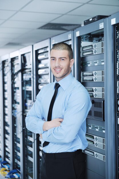 Jovem engenheiro de computadores na sala de servidores do centro de dados.