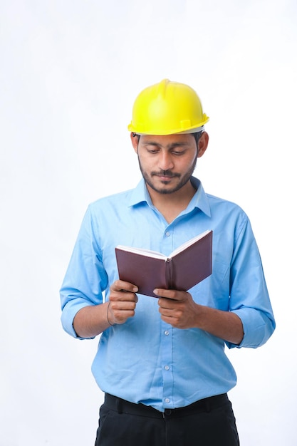 Jovem engenheiro indiano usando capacete e assistindo diário