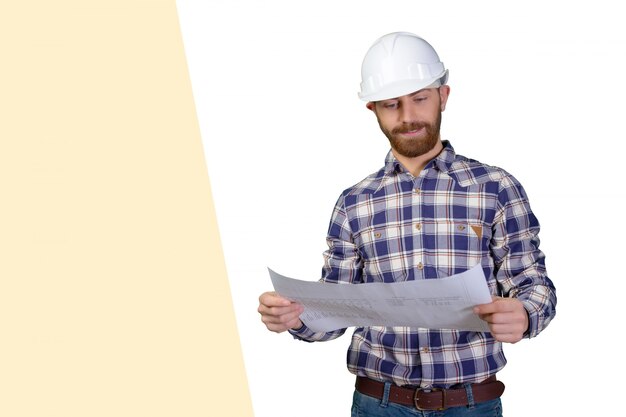 Jovem engenheiro masculino com capacete segurando plantas