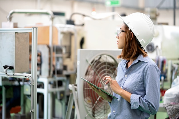 Foto jovem engenheiro mulher está verificando a programação na fábrica de automação.