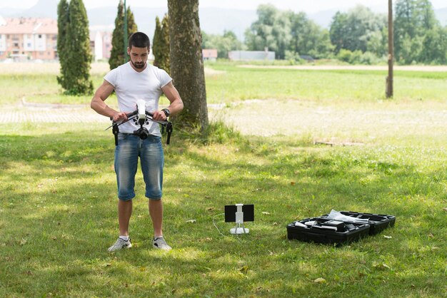 Jovem engenheiro prepara um drone para voar no parque