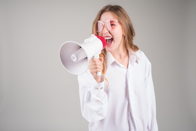 Jovem engraçada gritando no megafone