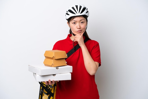 Jovem entregadora chinesa levando comida para viagem isolada no pensamento de fundo branco