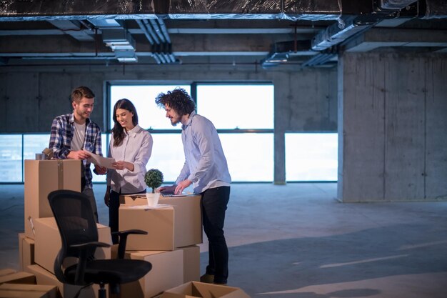 jovem equipe de empresários em grupo, arquiteto e engenheiro no canteiro de obras, verificando documentos e fluxo de trabalho de negócios usando computador portátil no novo escritório de inicialização