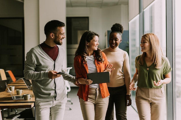 Jovem equipe multiétnica caminhando no escritório moderno