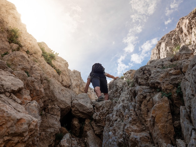 Jovem escalando uma montanha ao pôr do sol. aventura de conceito, exploração. (pedreforca, catalunha, espanha)