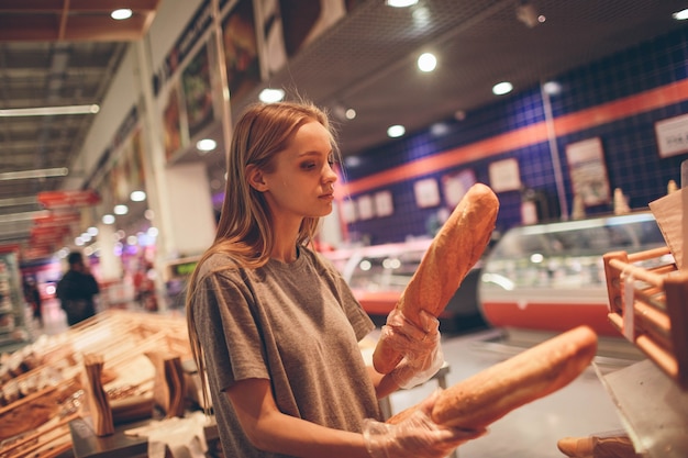 Jovem escolhe pão na loja