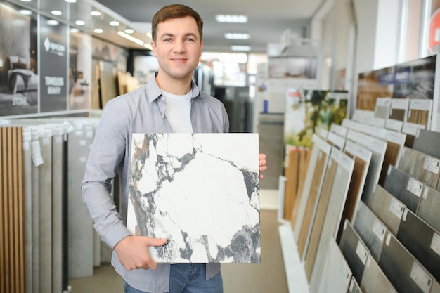 Jovem escolhendo azulejos no mercado de construção