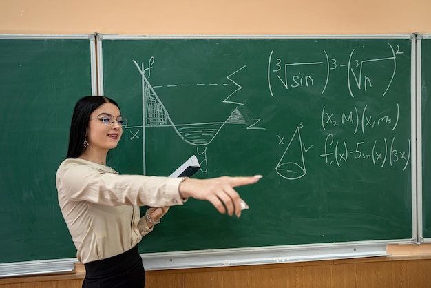 jovem escrevendo equações matemáticas no quadro-negro em sala de aula, aprenda