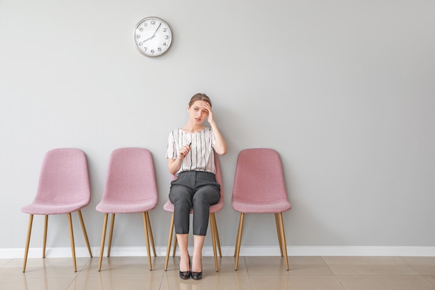 Foto jovem esperando para entrevista de emprego dentro de casa