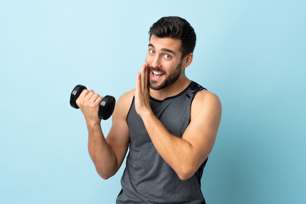 Jovem esportista com barba fazendo levantamento de peso e sussurrando algo