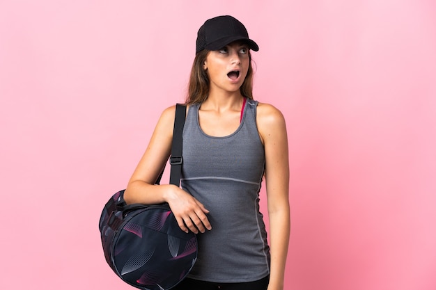 Jovem esportista com bolsa esporte rosa olhando para cima e com expressão de surpresa