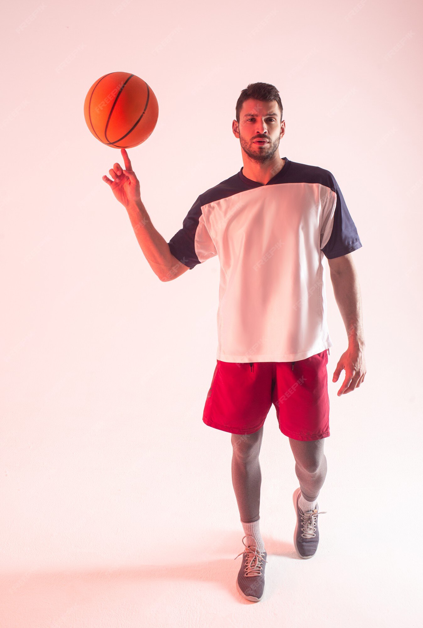 Girando a bola de basquete laranja em um dedo.