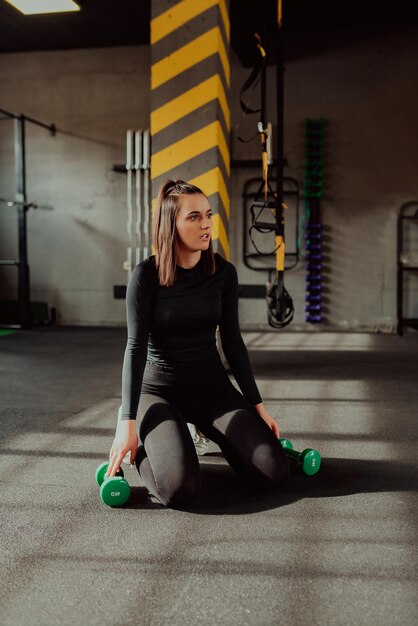 Jovem esportiva em roupas esportivas cansada e fazer uma pausa na academia