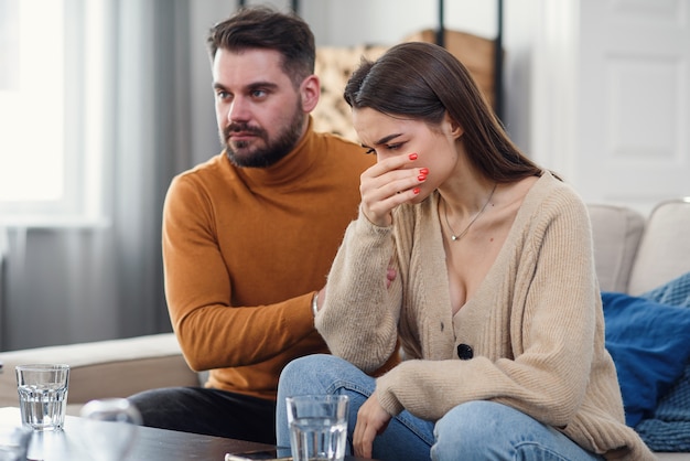 Jovem esposa amorosa, apoiando o marido deprimido durante a sessão de psicoterapia com conselheiro, espaço livre